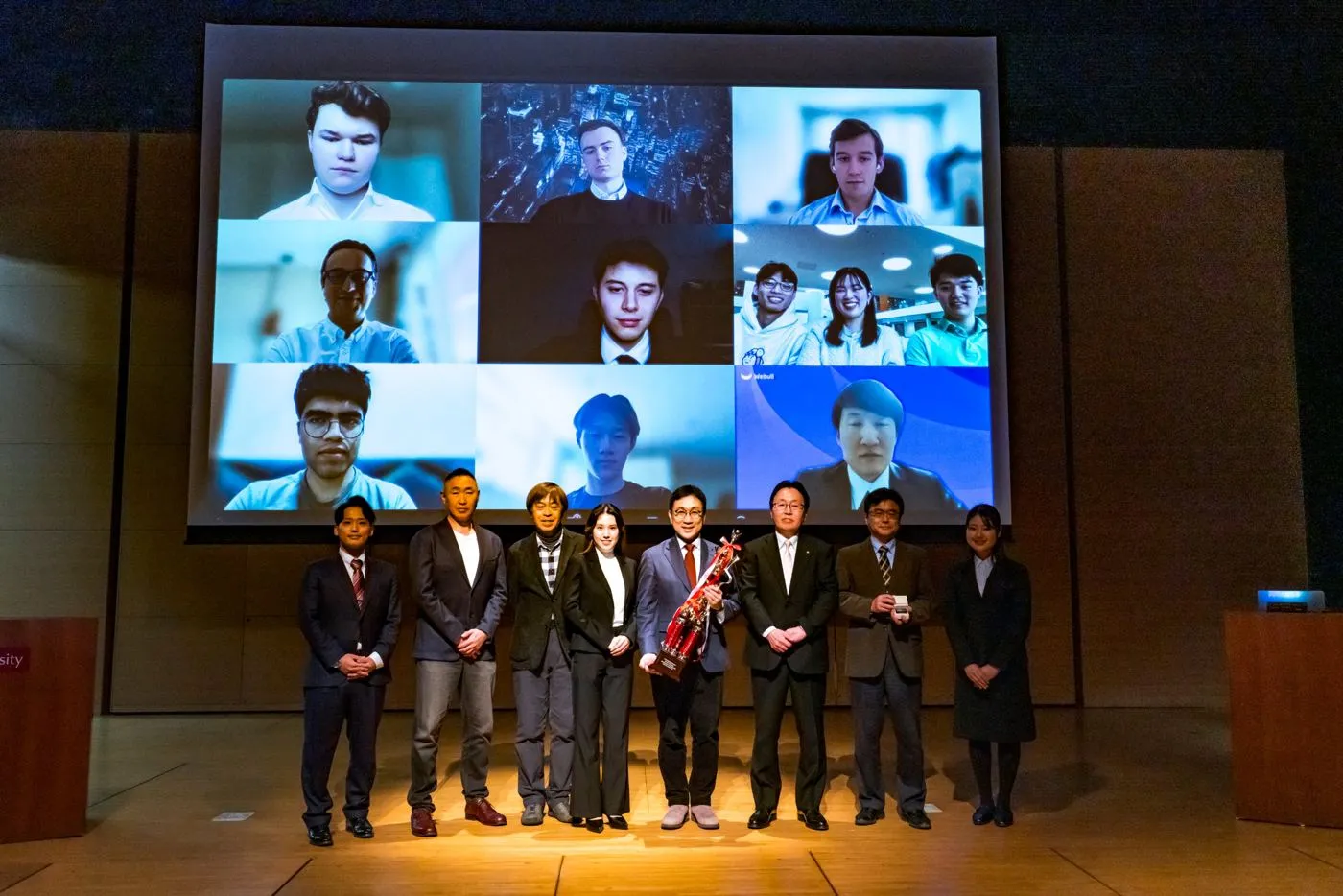 WIC2025 awards ceremony: judges and sponsors on stage, finalist teams joining on screen